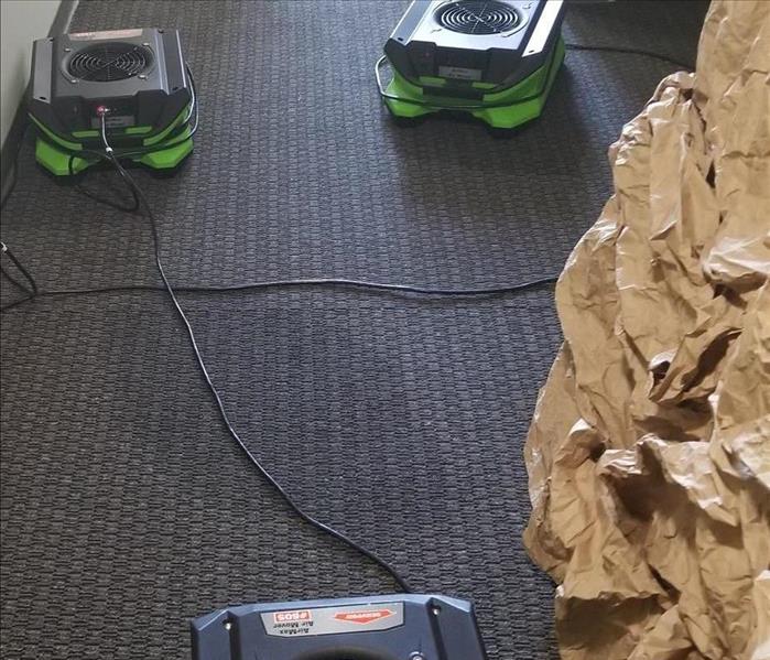 Photo is showing drying equipment in a carpeted hallway