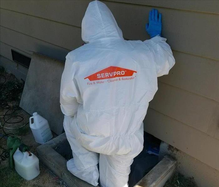 Photo is showing a technician wearing a full Tyvek suit with gloves, worn for protection