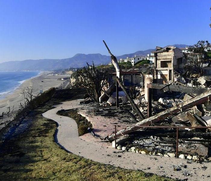 Photo is showing a home on the edge of the beach, destroyed by fire.