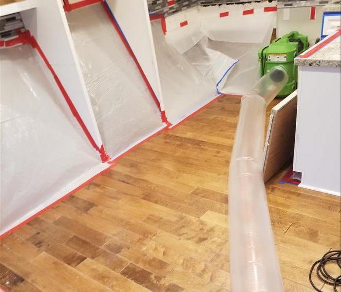 Photo is showing plastic containment in a kitchen with drying equipment in place