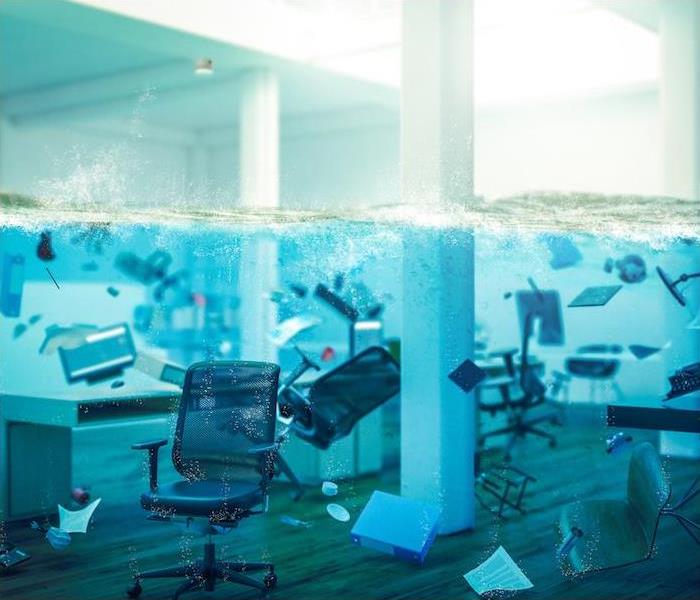 Photo is showing office materials such as, chairs, desks, monitors, folders being halfway submerged under water in an office