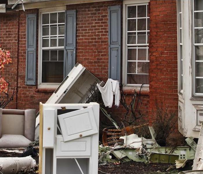 Photo is showing contents outside a home that are damaged or destroyed by water and/or fire. 